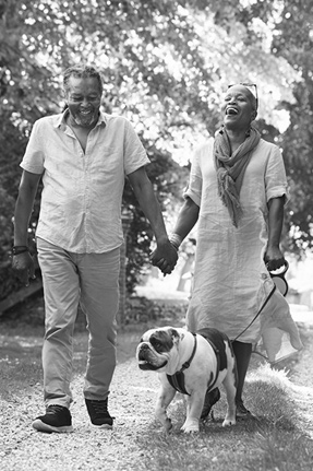 senior couple walking with pet bulldog